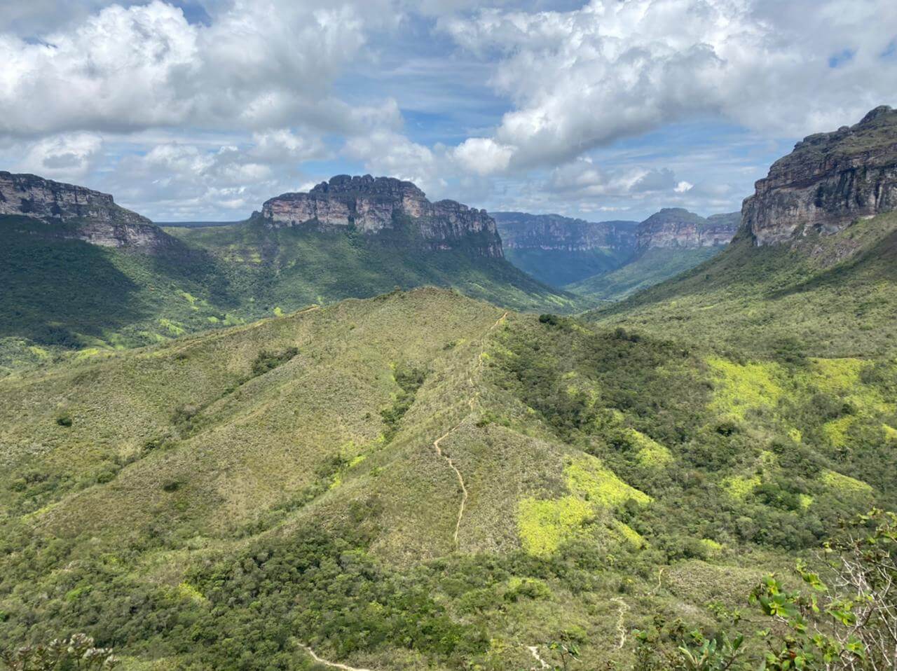 Mirante do Vale do Pati, onde dá para avistar um vale coberto de vegetação rodeado por uma cadeia de montanhas. Céu nublado.